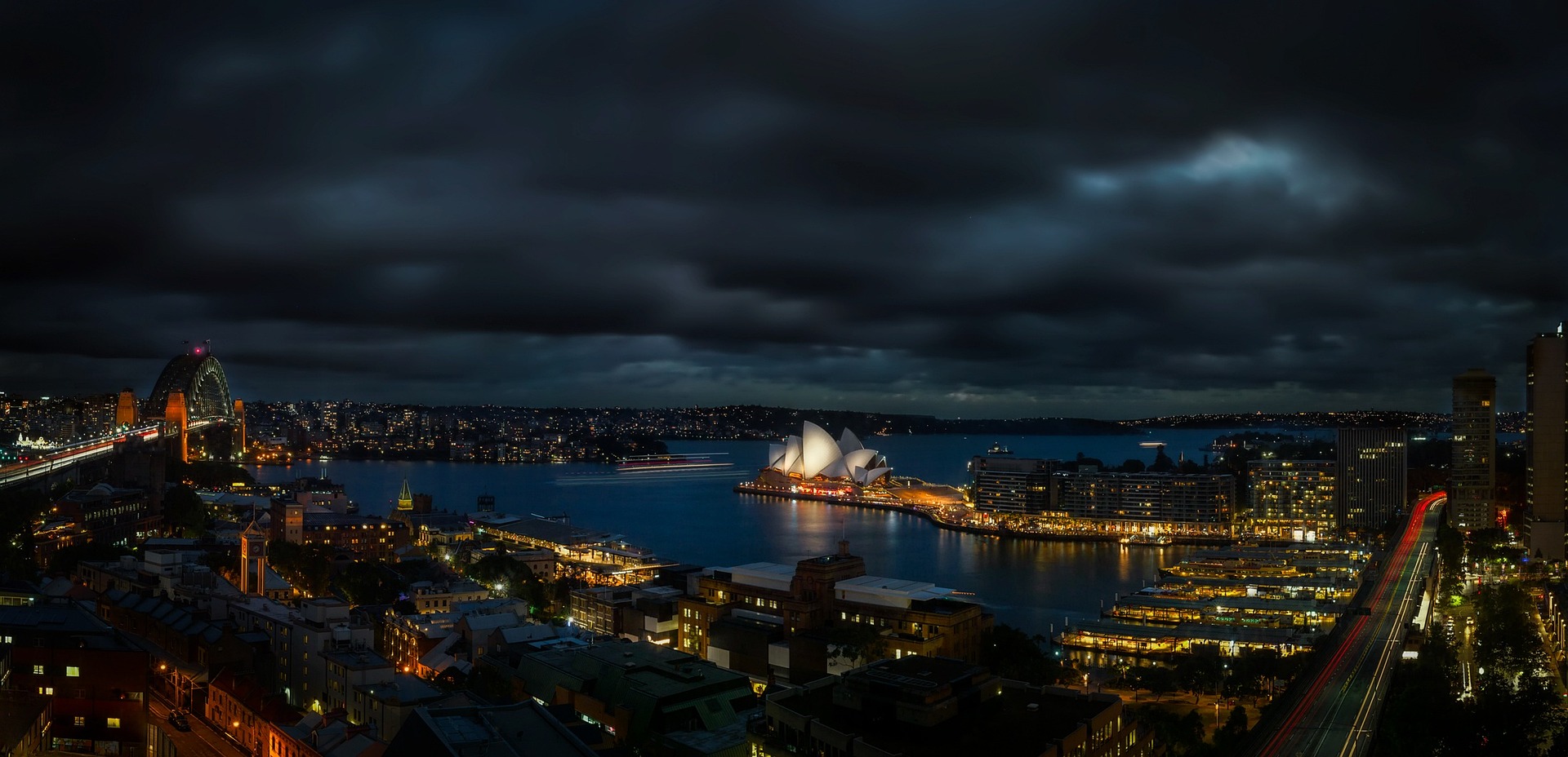 Sydney Harbour at night with the Opera House and Harbour Bridge illuminated